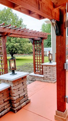 an outdoor patio with stone pillars and lanterns