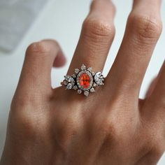 Immerse yourself in a world of timeless beauty with our Coco Fanta Orange Spessartite Garnet Coco Diamond Ring, a true testament to class and elegance. This ring seamlessly combines the grace of marquise and round diamonds, elevating the sense of style on the wearer. A proportionately beautiful design with a touch of vintage charm, it features a natural vivid Orange Spessartite adorned with the brilliance of natural white diamonds. Handcrafted with precision, this ring is available in 14K and 18K yellow gold, rose gold, and white gold. Only one available. Spessartite/Spessartine is known for its fiery red-orange color, hence why it's called the "Garnet of the sun". Spessartine garnet is a stone known for positive emotions and creativity. It encourages a rational state of mind, emotional st Luxury Orange Ring With Center Stone, Luxury Orange Diamond Ring, Classic Orange Diamond Ring, Luxury Orange Gemstone Accented Jewelry, Orange Gemstone-accented Ring Jewelry, Fanta Orange, Spessartine Garnet, Red Orange Color, Spessartite Garnet