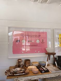 there is a pink tape on the wall next to bowls and other items in front of it