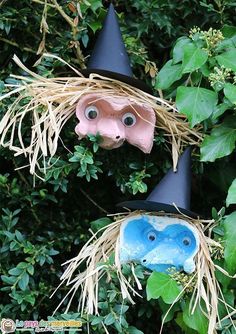 two scarecrows with hats on their heads are in the bushes