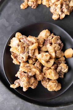 a black plate topped with cookies and nuts