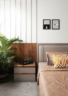 a bed sitting next to a plant on top of a wooden dresser in a bedroom