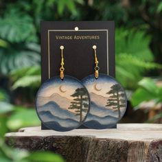 Mountain landscapes are some of the most breathtaking sights that nature has to offer. They inspire awe and wonder in anyone who takes the time to appreciate them. That's why these Mountain Landscape Dangle wood earrings are such a special and unique piece of jewelry. Handcrafted from lightweight materials, these hand-painted wooden earrings feature one-of-a-kind designs that capture the beauty and majesty of the mountains. Whether you're an avid hiker or simply appreciate the natural beauty of the world, these earrings are a must-have addition to your collection. The intricate detailing of the painted designs is truly impressive, and the lightweight construction makes them comfortable to wear all day long. Plus, the one-of-a-kind designs mean that you'll never see another pair of earrings Nature-inspired Dangle Earrings, Nature-inspired Natural Wood Earrings As Gift, Handmade Natural Nature-inspired Earrings, Nature-inspired Natural Wood Earrings For Gift, Natural Wood Nature-inspired Jewelry, Handmade Natural Color Nature-inspired Earrings, Handmade Natural Earrings With Nature-inspired Style, Natural Wood Drop Earrings, Natural Color Earrings For Gift