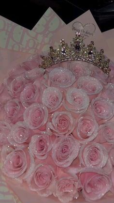 a bouquet of pink roses with a tiara on top