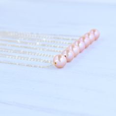 "Price is for one beautiful peachy pink Edison floating pearl necklace. Photos may feature multiple necklaces that can be purchased separately. If you are looking for Bridal Party or Bridesmaids sets, please contact me for pricing information. This chain is made from your choice of either gold filled or sterling silver and will not tarnish and can even get wet! We HIGHLY recommend selecting double rope chain (more durable) for longer necklaces 22\"-26\". Pearls are approximately 10-11mm round/ne Delicate Pink Necklace For Bridesmaid Gift, Peach Round Necklace For Gift, Peach Round Necklace Gift, Peach Necklace Gift, Round Peach Necklace For Gift, Gift Round Peach Necklace, Dainty Pink Necklace For Bridesmaid Gift, Pink Pearl Charm Necklace For Wedding, Pink Pearl Drop Necklace Gift