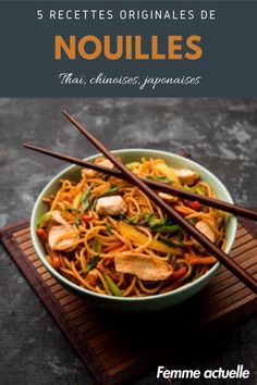 a bowl of noodles with chopsticks in it on top of a wooden table