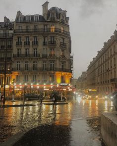 people are walking down the street in the rain