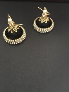 These are purely handmade dangling chandelier style earrings in silk thread wrapped jumka .available in 2 colours black / blurb silk thread with pearl & gold hooks earrings  Kindly specify which one you wish to buy when you place your order  These are an authentic Indian traditional earrings that could be worn by both traditional and an western attire. Note: The product shipped will be same as shown in the picture however, actual colours may vary slightly from those shown due to lighting in the photography. Pls note The shades of gold / silver  may vary slightly. We do not accept any returns or refunds.However in case of any issue we will definitely try and resolve it! Elegant Handmade Beaded Earrings For Festive Occasions, Traditional Handmade Pearl Earrings For Party, Traditional Tassel Earrings For Festive Occasions, Black Dangle Jhumkas, Handmade Pearl Earrings For Party And Festive Occasions, Traditional Gold Beaded Earrings With Tassels, Elegant Handmade Jhumkas For Parties, Bohemian Black Jhumkas For Festive Occasions, Traditional Black Dangle Jhumkas