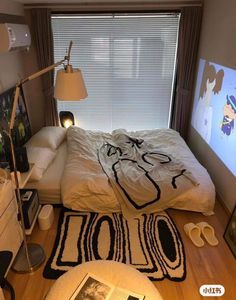 a bed room with a neatly made bed and pictures on the wall