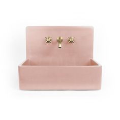 a pink sink with two gold handles on the front and back of it, against a white background