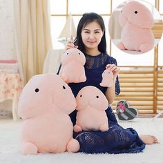 a woman sitting on the floor with four pink stuffed animals in front of her,