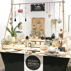 a table with plants and other items on it at muddy heart ceramics studio in london