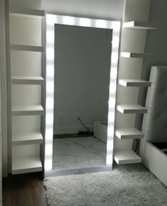 a large white mirror sitting on top of a wooden floor next to a book shelf