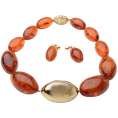 Unusual amber necklace with oval stones centered with a large 14 karat gold bead. The gold center measures 2 1/8" in width. The necklace can actually be worn in reverse with the decorative clasp as the front. It is a similarly shaped gold bead with openwork like coral branches. The necklace measures 19" long. Accompanying earrings are amber beads hung from a gold circle. They are 1 3/4" long.The clip backs can be changed to posts. The clasp is signed in script with a name I cannot decipher. Amber Bead Necklace, Gold Link Necklace, Original Necklace, Round Bead Necklace, Beading Jewelry, Vintage Necklaces, Jewelry Antique, Jewelry Beaded, Gold Choker Necklace