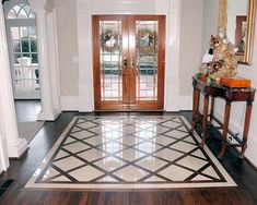 a foyer with an ornate tile floor and double doors leading to the front entrance area