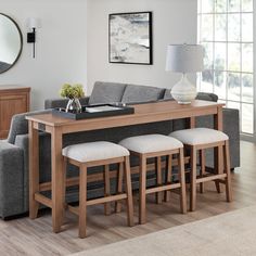 a living room filled with furniture and a table topped with stools next to a couch