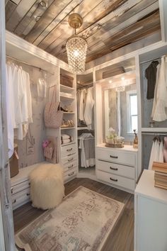 a walk in closet filled with lots of white furniture and hanging clothes on shelves next to a rug