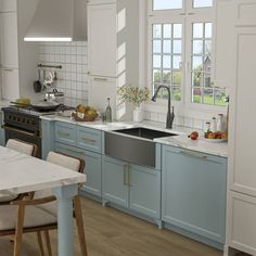 a kitchen with blue cabinets and an island in the middle is seen from across the room