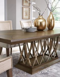 a dining room table with two vases on it