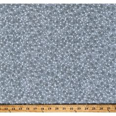 a ruler is next to a fabric with small white stars on it and blue background