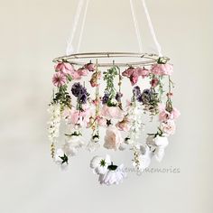 a mobile with flowers hanging from it's sides