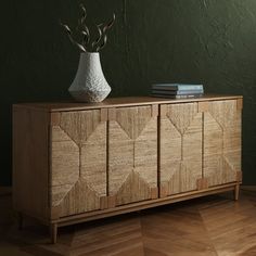 a wooden cabinet with two vases on top of it next to a book shelf