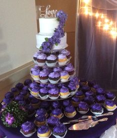 a wedding cake and cupcakes on a table