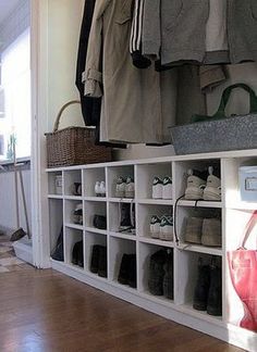 a white shelf filled with lots of shoes and bags