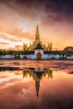 an image of a building that is reflecting in the water at sunset or sunrise time