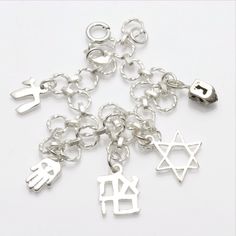 This stunning link bracelet has 5 charms dangling from it. (1) three dimensional dreidel (1) diamond cut star of David (1) Ahava - which means love in Hebrew (1) Hamsa with an evil eye (1) chai. The bracelet is made entirely of sterling silver and has a spring ring clasp. Makes a great Bat Mitzvah gift!!! The bracelet is 7" long. Love In Hebrew, Jewish Symbol, Jewish Symbols, Bat Mitzvah Gifts, Hamsa Pendant, Star Of David Pendant, Sterling Silver Filigree, Filigree Design, Star Of David