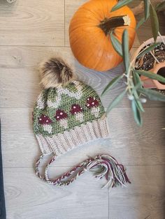 a knitted hat sitting on top of a wooden floor next to a potted plant