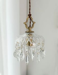 a glass chandelier hanging from a ceiling in a room with white walls and windows