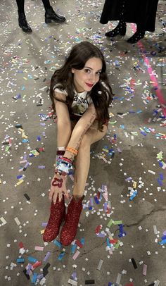 a woman sitting on the ground surrounded by confetti