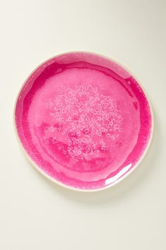 a pink plate with white sprinkles on the rim is shown from above