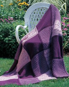 a purple blanket sitting on top of a white chair