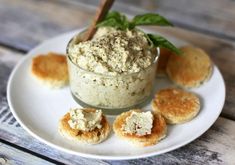 a white plate topped with food on top of a wooden table next to small cookies