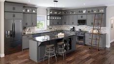 a large kitchen with gray cabinets and stainless steel appliances, along with wooden flooring