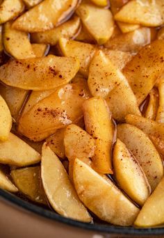 sliced apples are in a glass dish with brown sugar on top and seasoning sprinkled over them