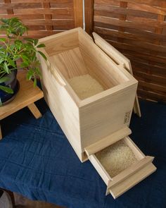 a wooden box sitting on top of a blue blanket next to a potted plant