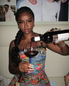 a woman is holding a glass of wine