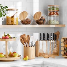 kitchen utensils and wooden spoons are arranged on the shelves above the counter