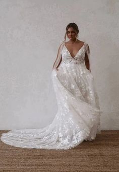 a woman in a white wedding dress standing on the floor with her back to the camera