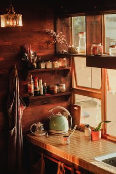 a tea kettle sitting on top of a kitchen counter next to a sink and window