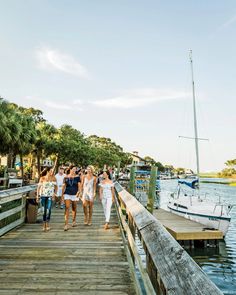 several people walking on a dock near a boat