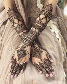 two hands with henna tattoos on them