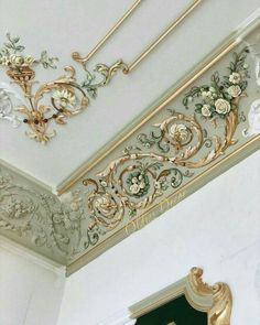 the ceiling is decorated with gold and white flowers on it's trimmings