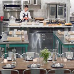 a chef preparing food in a kitchen with lots of counter space and chairs around the table