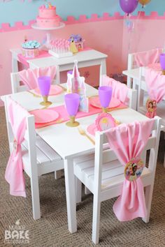 a table set up for a princess party with pink napkins and purple cups on it