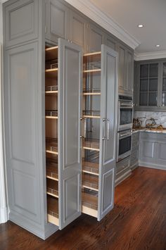 a kitchen with gray cabinets and wood floors