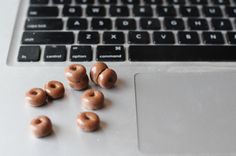 some chocolate donuts are on the keyboard of a laptop